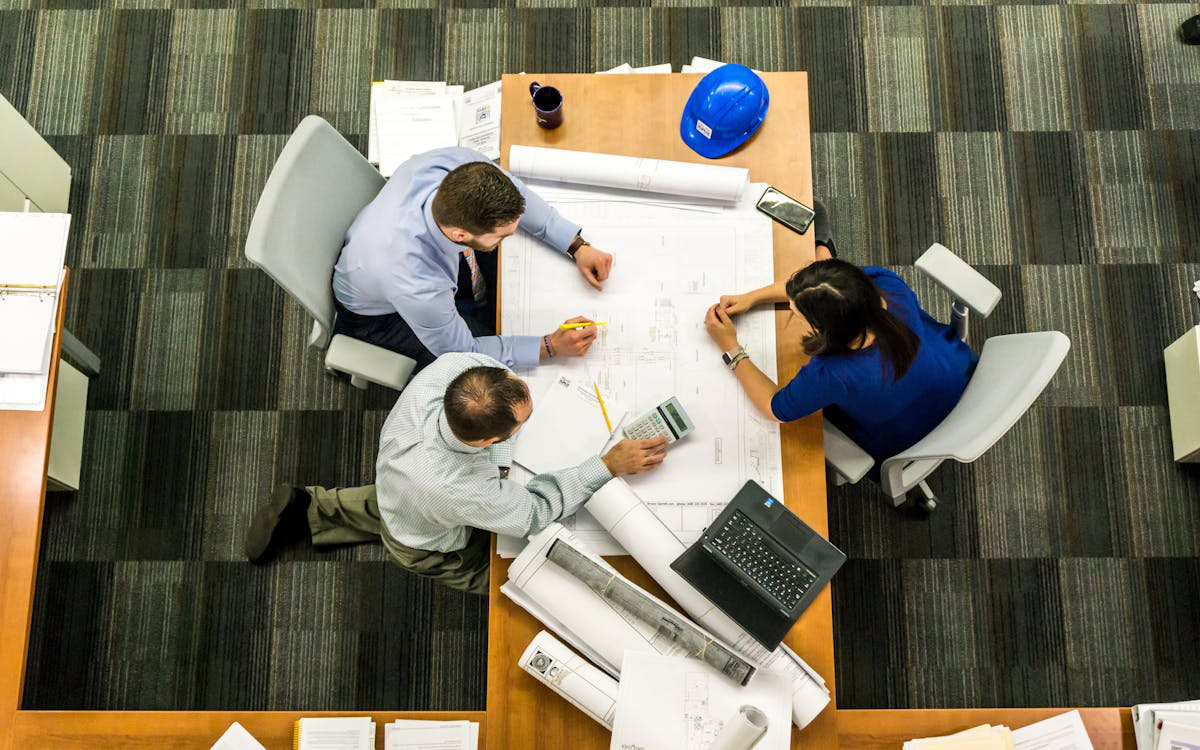 Construction safety consultants in a safety meeting, reviewing plans and discussing procedures.