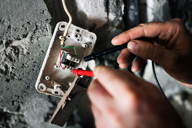 A construction worker works on an electrical panel.